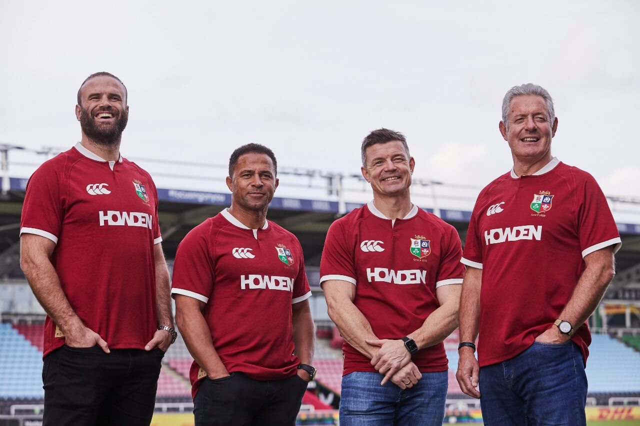 Jamie Roberts, Jason Robinson, Brian O'Driscoll, and Gavin Hastings standing and smiling in a rugby stadium